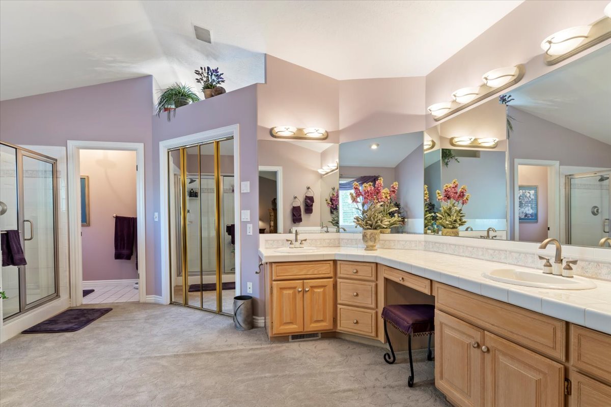 Spacious bathroom featuring a dual vanity with integrated sinks, ample counter space, and extensive mirrored wall