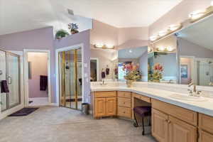 Spacious bathroom featuring a dual vanity with integrated sinks, ample counter space, and extensive mirrored wall
