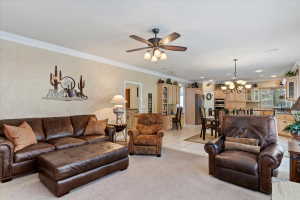 Open-concept living area featuring neutral walls and crown molding