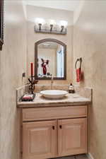 Vanity featuring a vessel sink, tile countertop, and tile backsplash