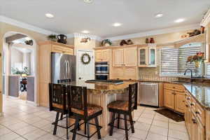 Kitchen featuring light wood cabinetry, granite countertops, and stainless steel appliances including a built-in double oven