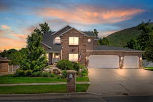 Stately two-story residence featuring a stone and stucco facade, a two-car garage, and a concrete driveway