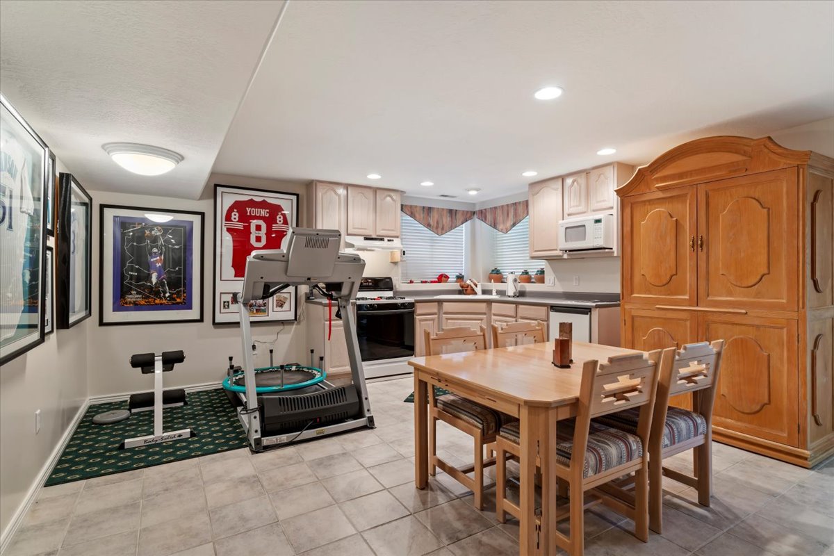 Well-appointed kitchen area featuring light wood cabinetry, dark countertops, and tile flooring