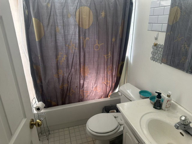 Bright bathroom featuring a white vanity with integrated sink, white subway tile backsplash, and a white bathtub