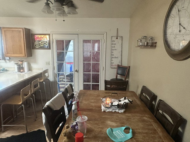 Kitchen and dining area featuring wood cabinetry, white countertops, and a ceiling fan with integrated lighting
