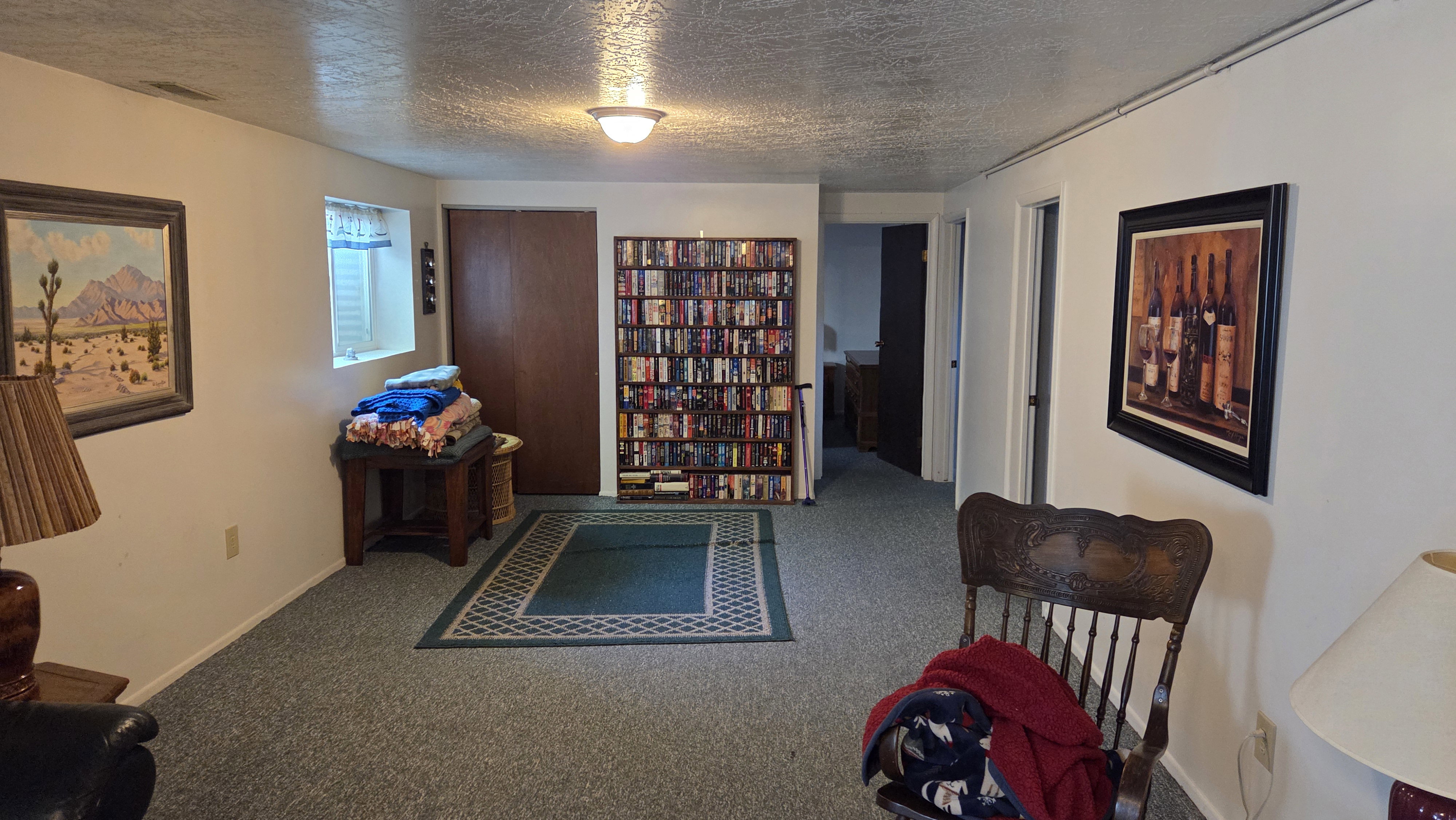 Carpeted room featuring a ceiling-mounted light fixture, white painted walls, and wood-finish doors