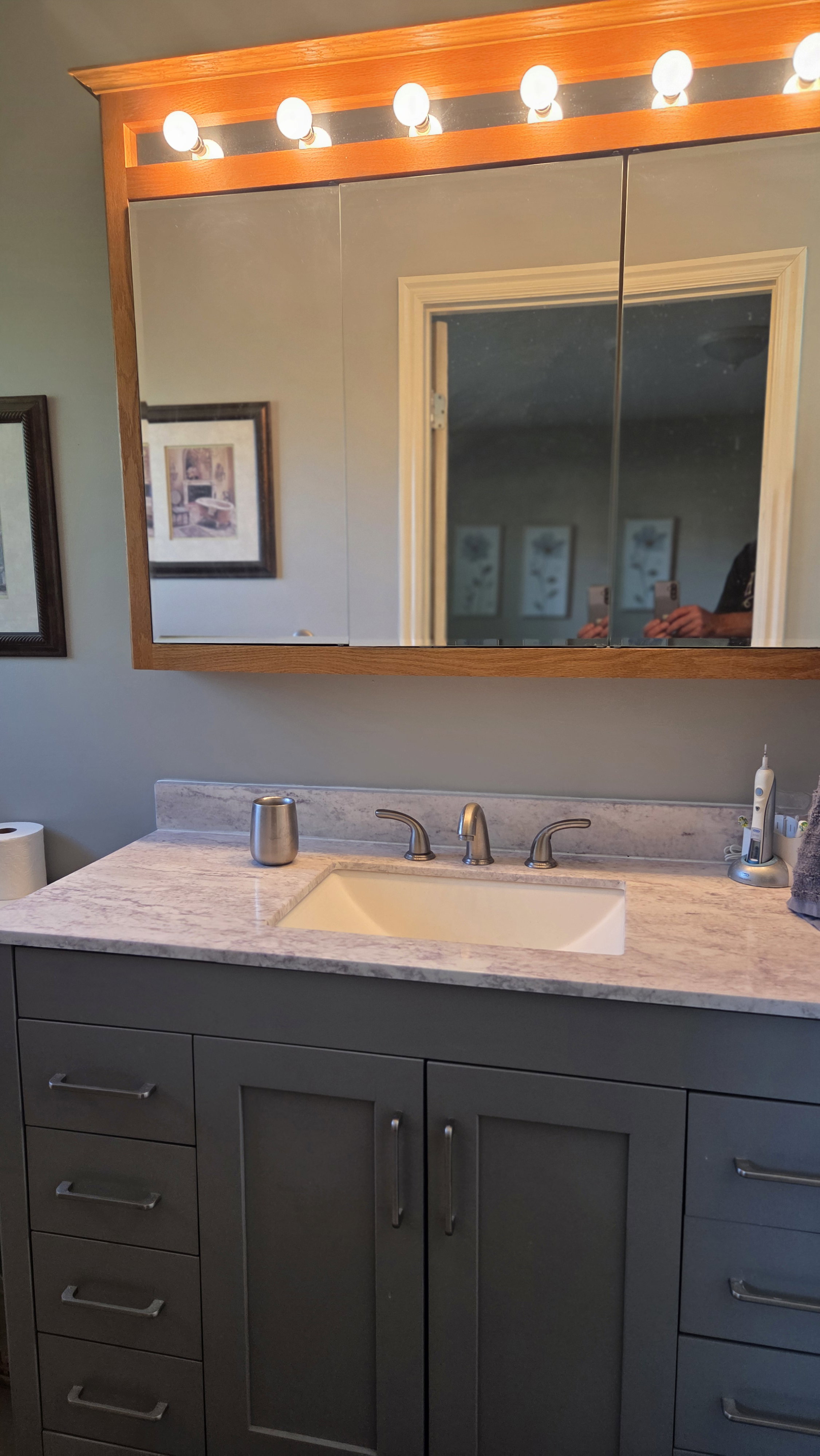 Bathroom vanity featuring a light-toned countertop, an undermount sink, and a brushed nickel faucet