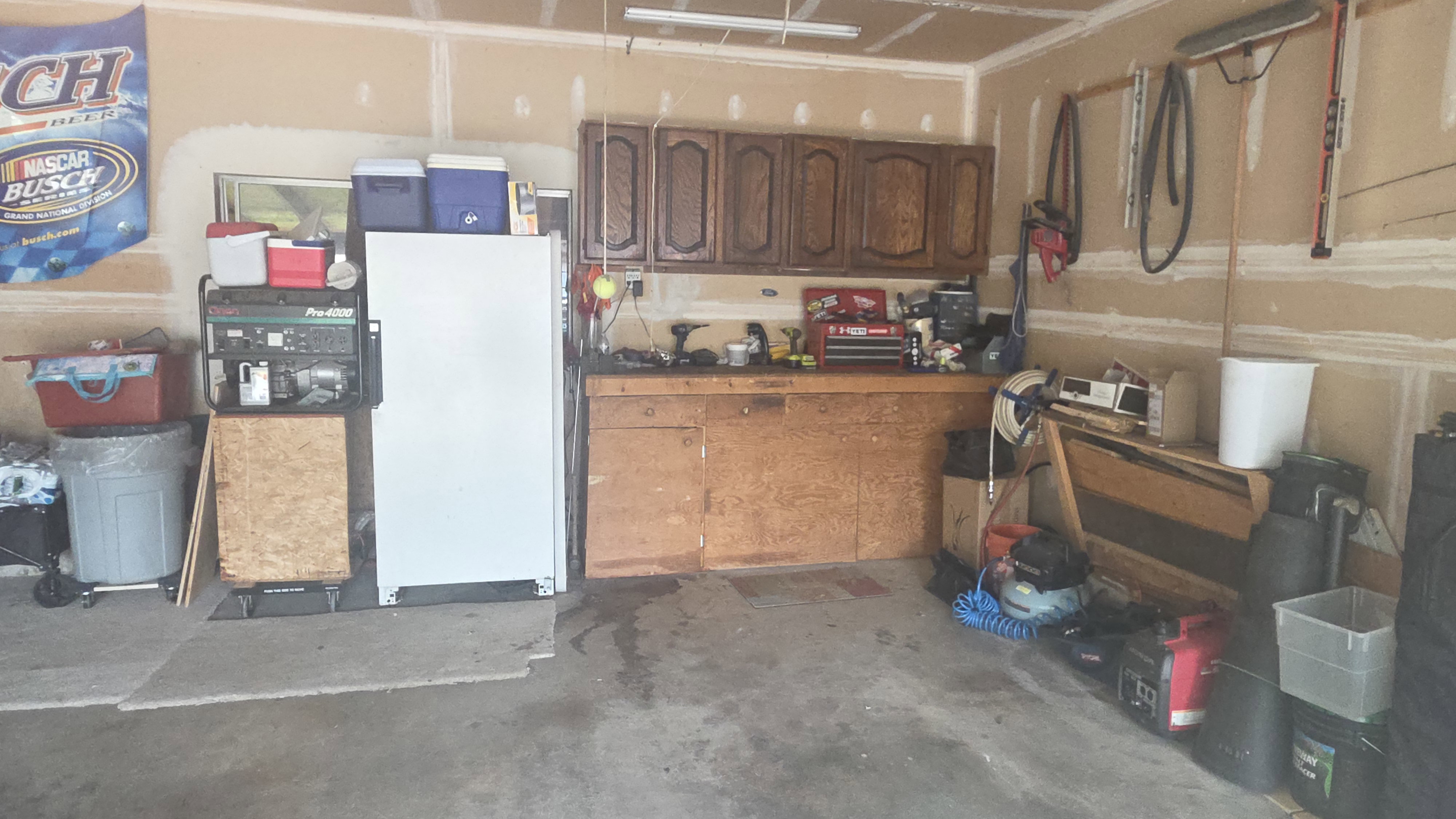 Garage workshop featuring wood cabinetry and a dedicated workbench