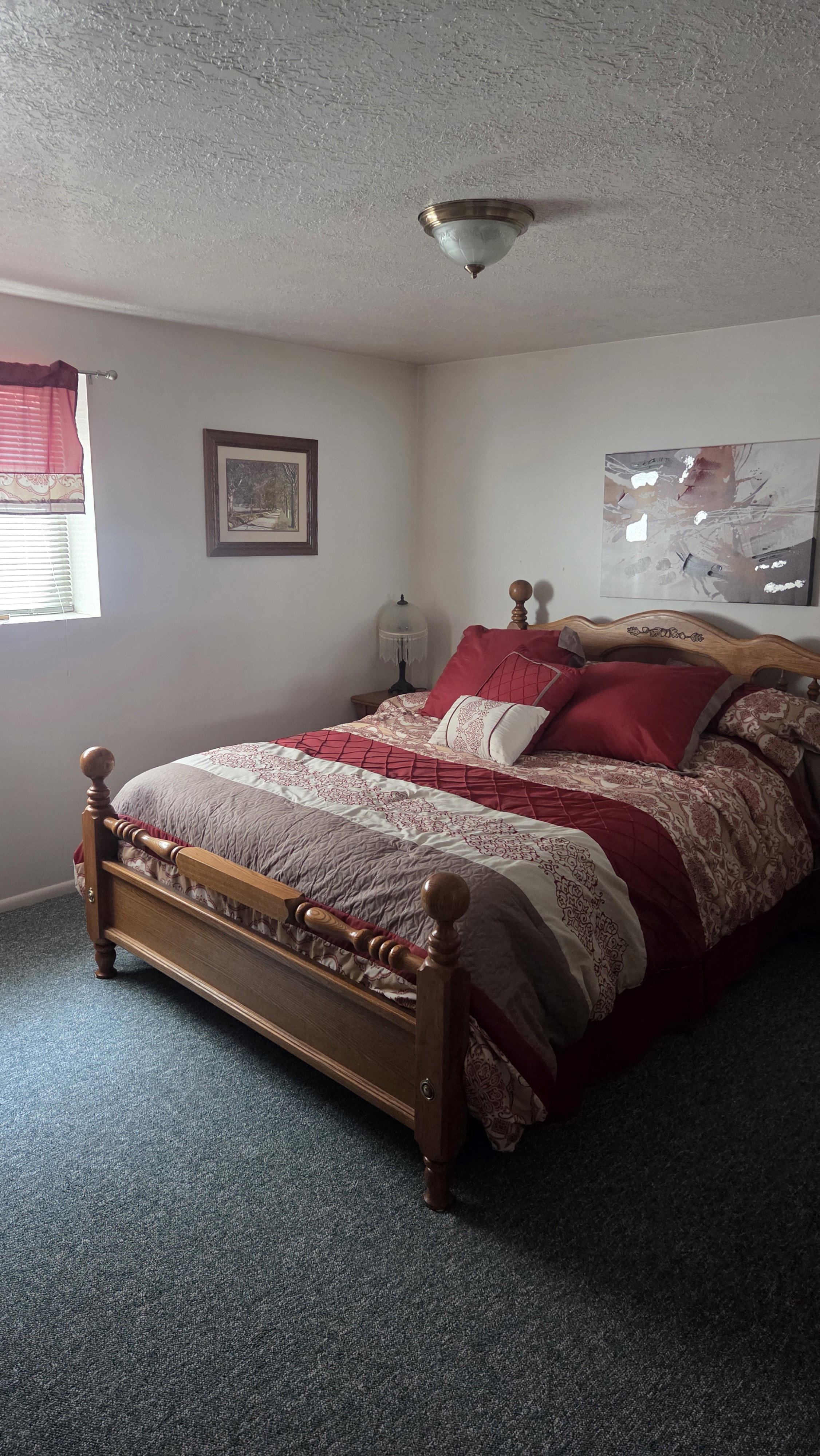 Room featuring textured wall-to-wall carpeting, white walls, and a window with blinds