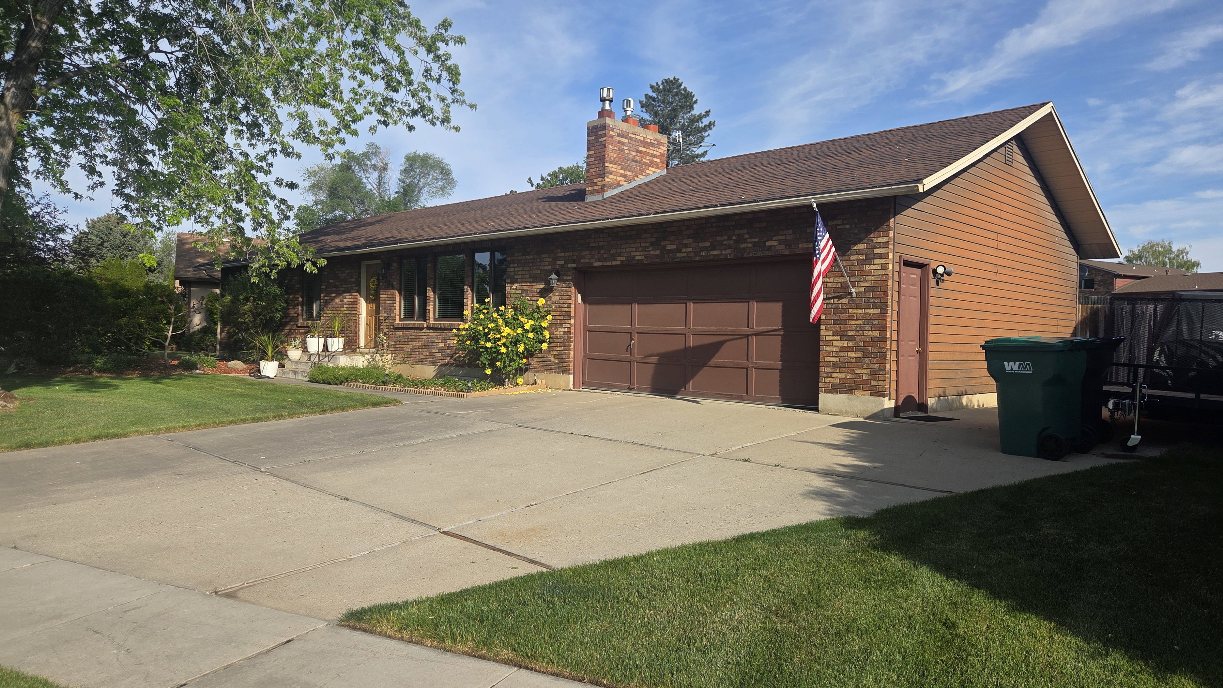 Brick and siding exterior featuring a brown asphalt shingle roof
