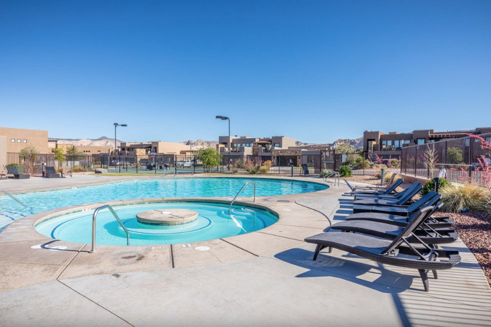 Resort-style pool area featuring a large swimming pool, integrated spa, and concrete deck