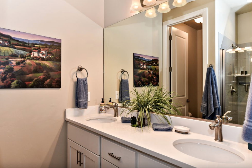 Bathroom featuring a double vanity with white countertops, undermount sinks, brushed nickel faucets, and coordinating cabinet hardware
