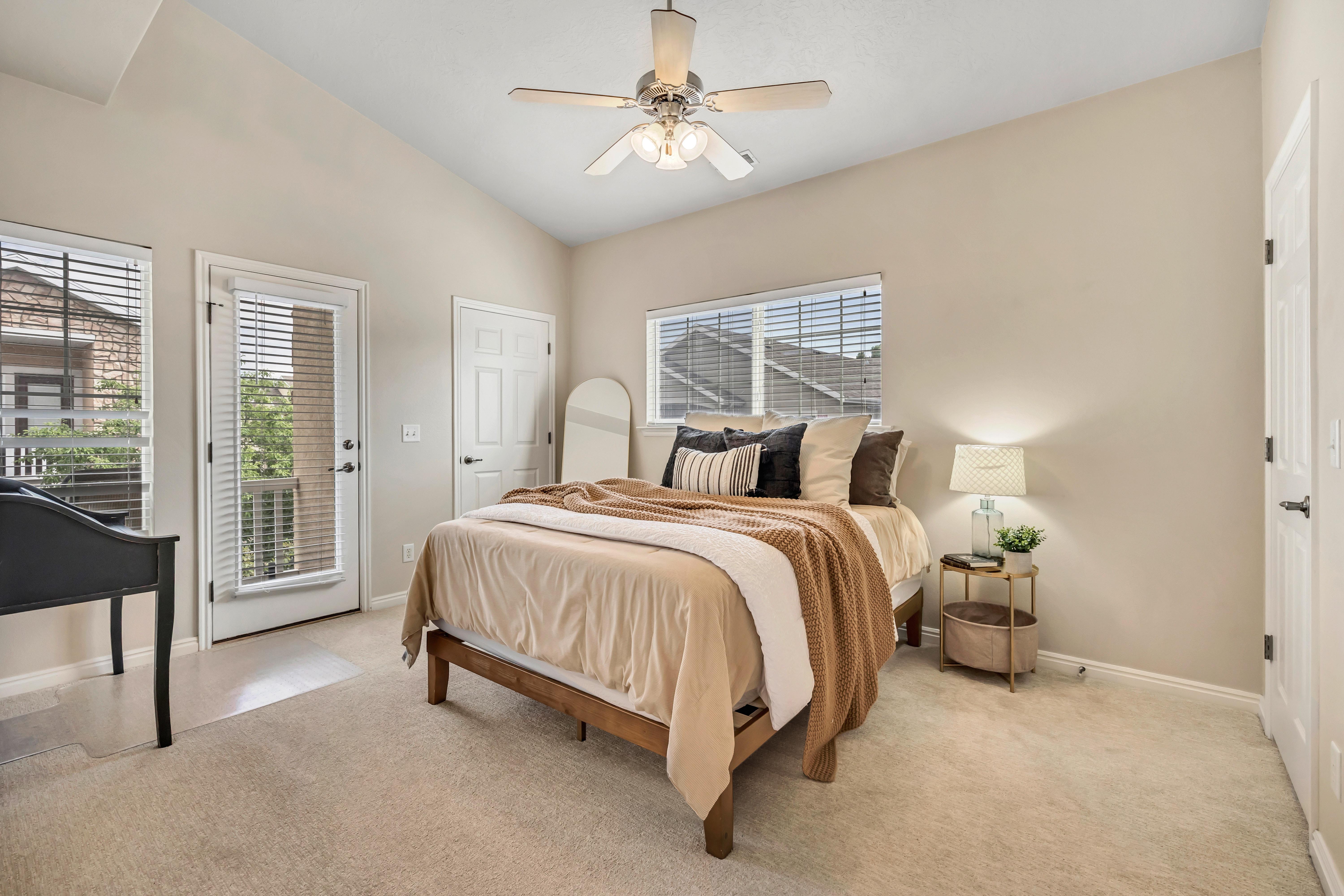 Main bedroom suite with vaulted ceiling, double walk-in closets, walk-out to deck, full bathroom with dual vanity.