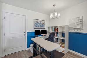 Room featuring wood-finish flooring, white paneled door, and two-tone wall treatment