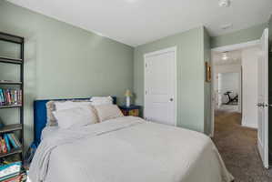 Bedroom featuring light green walls, white trim, and a white interior door