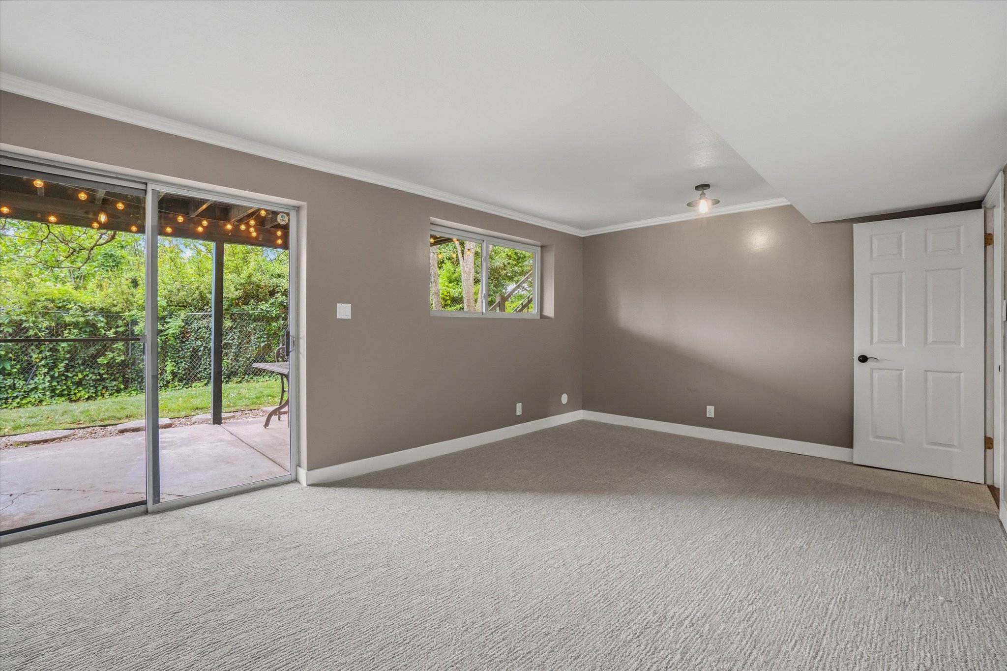 Spacious room with light gray carpeting and neutral-toned walls