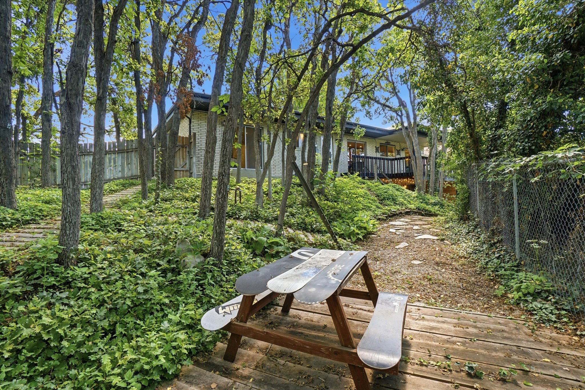 Wood decking and gravel pathway leading through a wooded backyard
