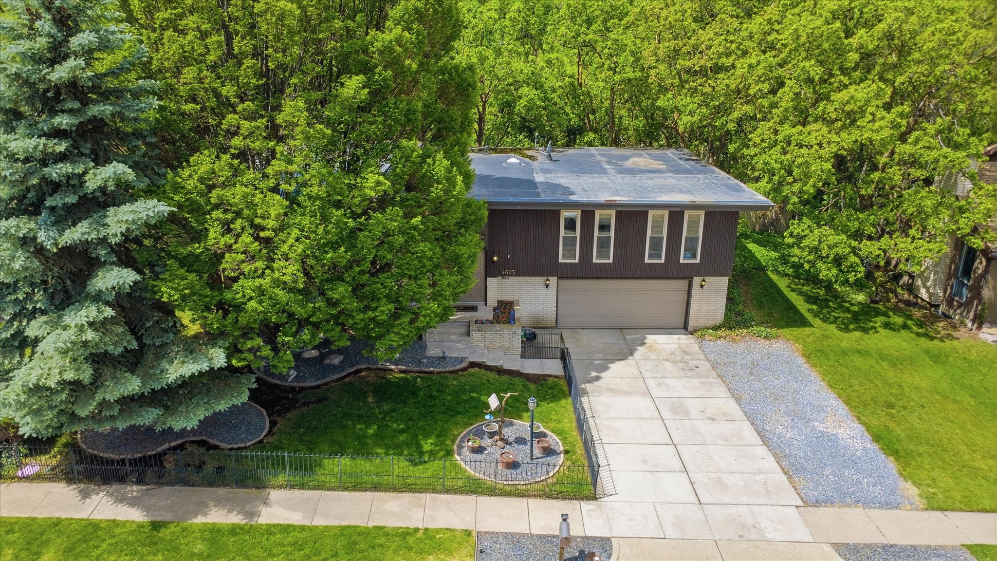 Split-level residence featuring a two-car garage and a concrete driveway