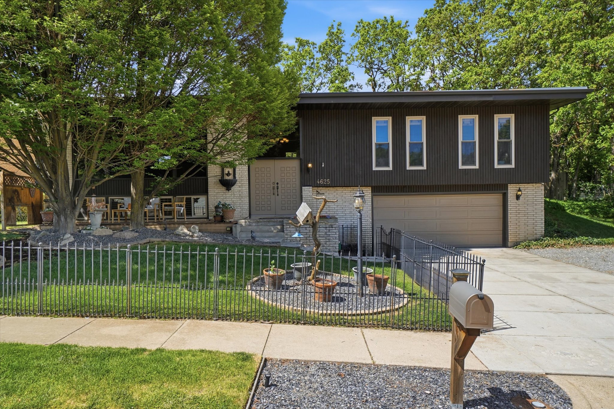Split-level residence featuring a dark wood-paneled upper level and a light brick lower level