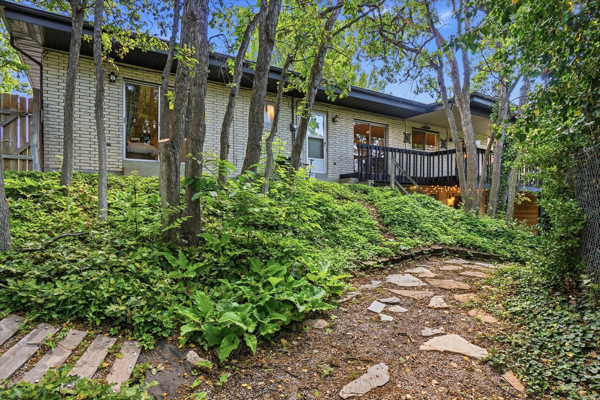 Wooded exterior featuring light-colored brick siding and a flat roofline