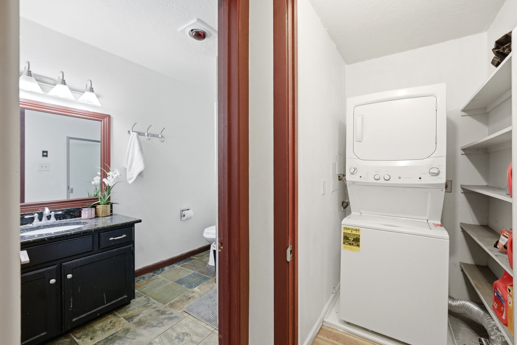 Bathroom featuring a dark wood vanity with a stone countertop and a rectangular mirror