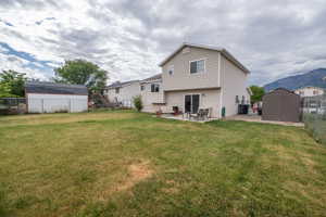 Expansive grass yard with a large patio and sliding glass door access to the residence