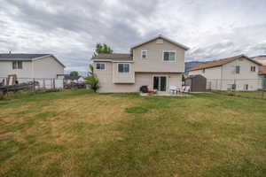 Expansive backyard featuring a patio with direct sliding door access, a storage shed, and a privacy fence
