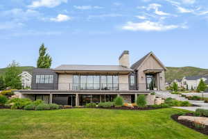 Contemporary exterior featuring stacked stone, vertical wood-finish siding, and dark metal accents