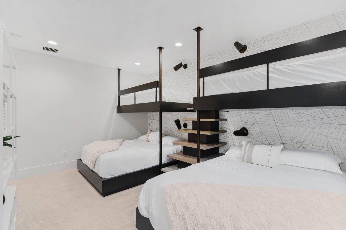 Room featuring built-in bunk beds with black metal framing and integrated shelving