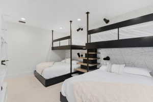 Room featuring built-in bunk beds with black metal framing and integrated shelving