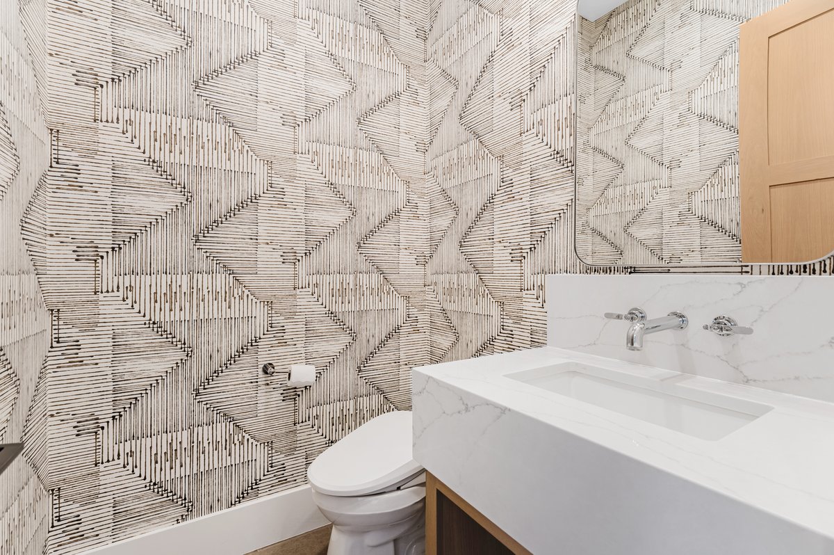 Powder room featuring a floating vanity with an integrated rectangular sink, wall-mounted chrome fixtures, and a coordinating backsplash