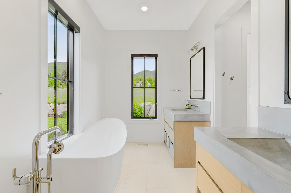 Freestanding soaking tub with polished chrome floor-mounted faucet