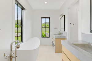 Freestanding soaking tub with polished chrome floor-mounted faucet