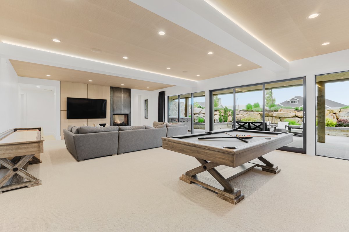 Expansive recreation room with recessed lighting and a wood-paneled ceiling feature