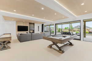 Expansive recreation room with recessed lighting and a wood-paneled ceiling feature