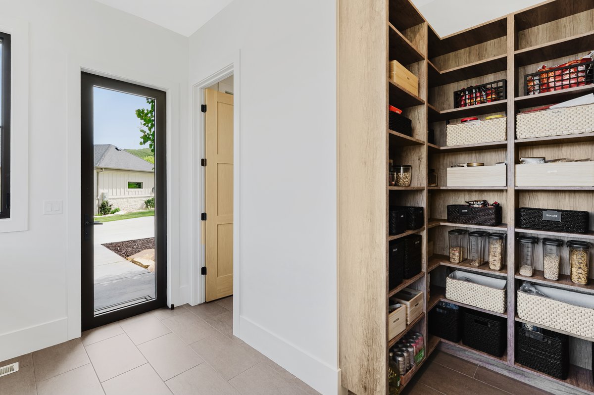 Spacious walk-in pantry with extensive wood-finish shelving