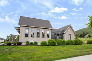Contemporary architectural exterior featuring vertical light-toned siding and dark pitched roofing