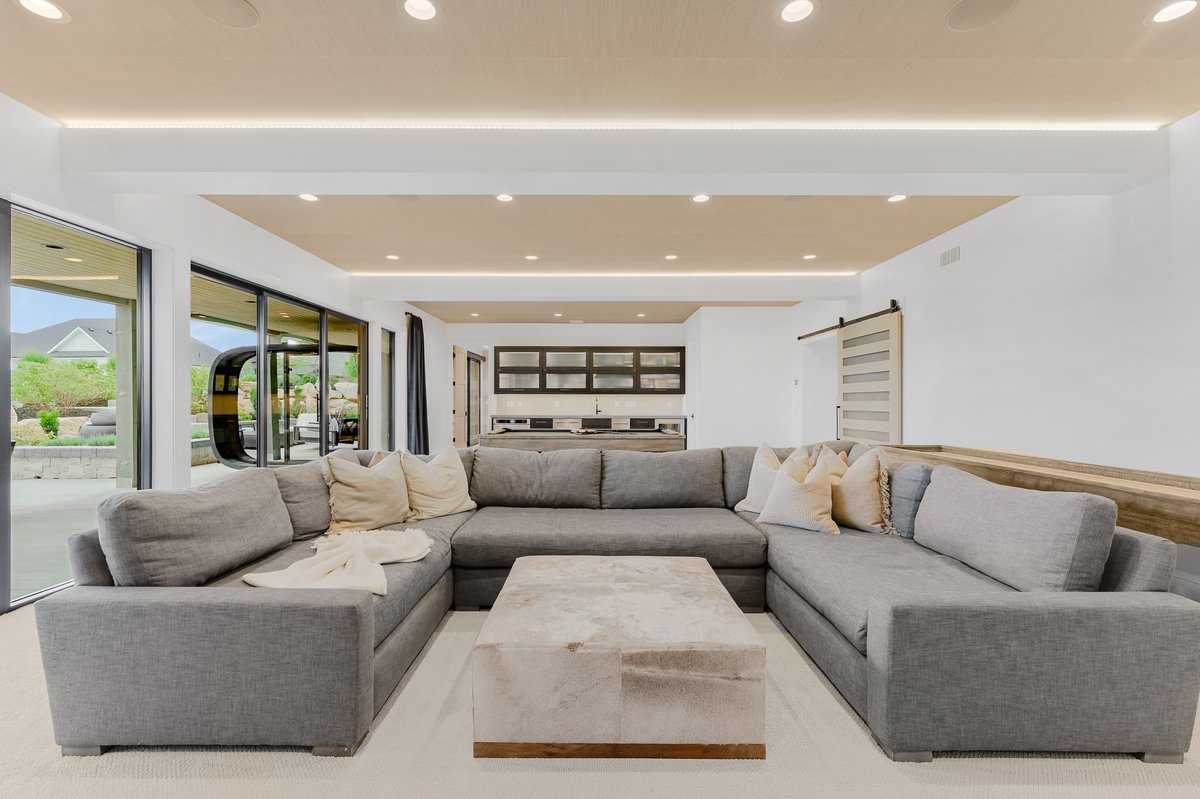 Open-concept living area featuring an architectural ceiling with recessed lighting and a perimeter light coves