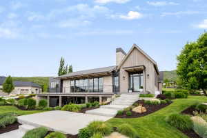Modern exterior featuring wood-finish siding, stone accents, and a prominent gable entry