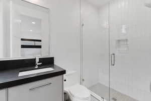 Full bathroom featuring a frameless glass shower enclosure, a recessed shower niche, and mosaic tile shower flooring