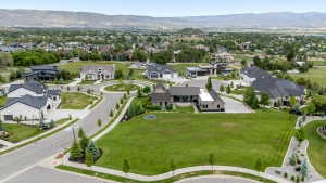 Expansive green lot with established landscaping, circular driveways, and mountain scenery