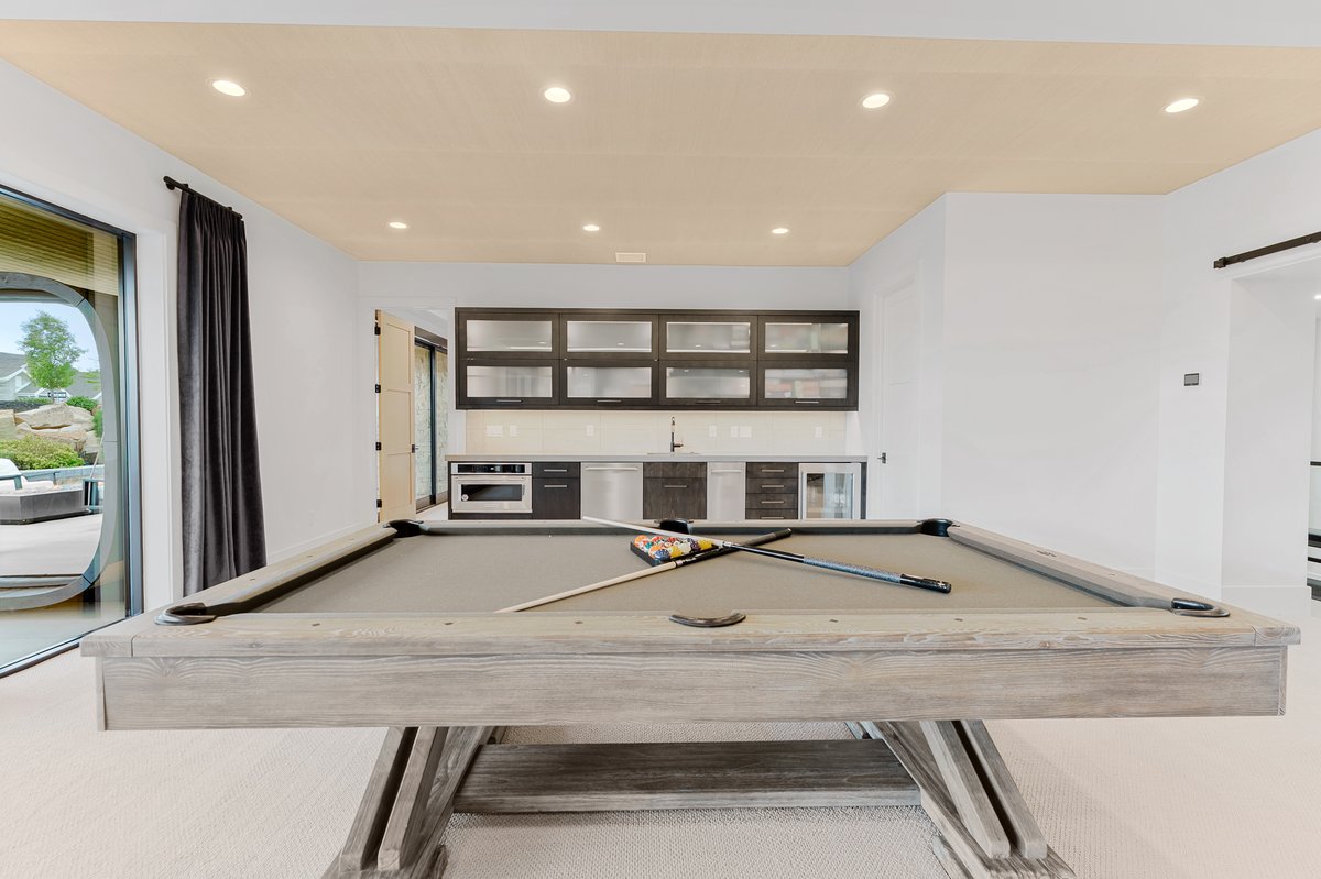 Recreation room featuring a pool table, a built-in wet bar with cabinetry and appliances, recessed lighting, and a sliding glass door leading to the exterior