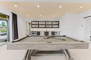 Recreation room featuring a pool table, a built-in wet bar with cabinetry and appliances, recessed lighting, and a sliding glass door leading to the exterior