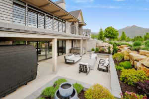 Expansive ground-level patio featuring a concrete surface, a built-in planter, and a swing bench