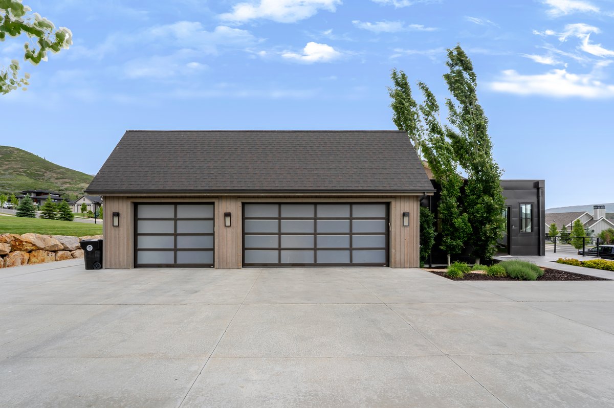 Contemporary two-car garage featuring frosted panel doors and integrated wall sconces