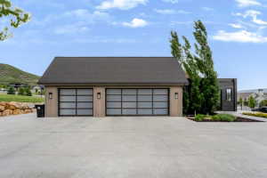 Contemporary two-car garage featuring frosted panel doors and integrated wall sconces