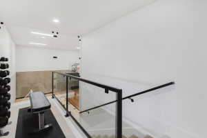 Modern interior featuring a glass and black metal railing system