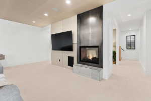 Open concept living area featuring a modern fireplace with a dark, textured surround