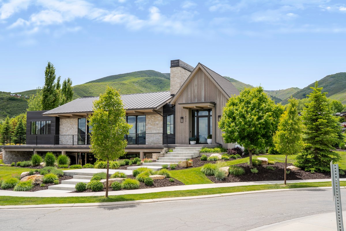 Modern architecture featuring a blend of stone, wood-finish siding, and dark paneling