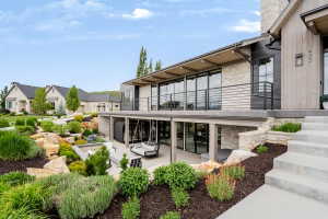 Stone and wood-clad exterior with a prominent balcony featuring horizontal bar railings